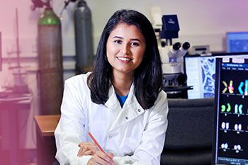 Female student in lab coat studying in laboratory