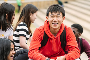 Student in social group wearing a red hoodie
