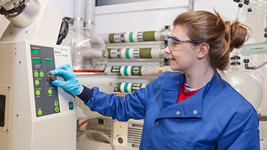 Female student in engineering lab wearing PPE