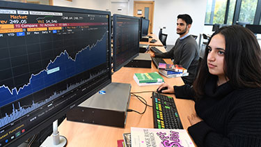 Female student looking at finance data on computer