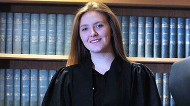 Female law student standing infront of books