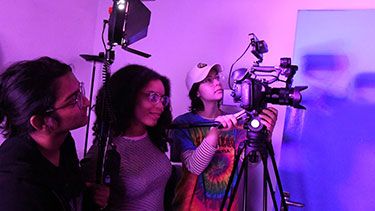 Students working with camera on a film set